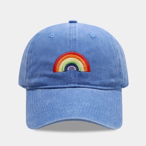 Close-up of rainbow embroidery on washed cotton blue baseball cap with curved brim
