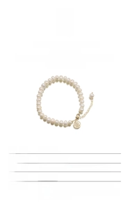 Detail showing natural baroque pearls and gold Fu charm on an elegant luxury bracelet