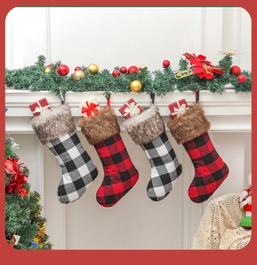 Large red and black buffalo plaid Christmas stockings hanging on a festive fireplace mantel