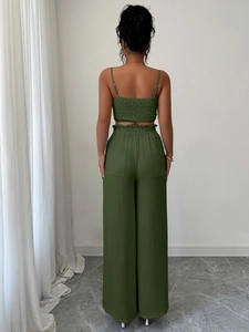 Vista posteriore del completo verde due pezzi con crop top a pieghe e pantaloni a gamba larga