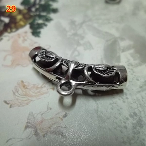Macro shot of retro silver curved tube bead with leaf relief and ring for DIY jewelry