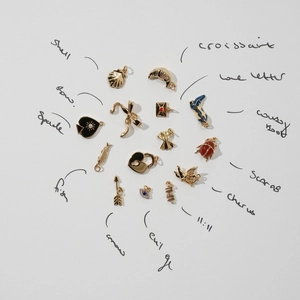 Flat lay of vintage gold-plated charms including heart, boots, and beetle for DIY jewelry