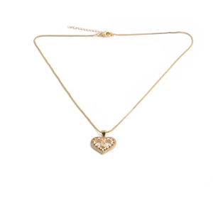 Macro shot of gold heart pendant with crystal border and intricate winged angel detail