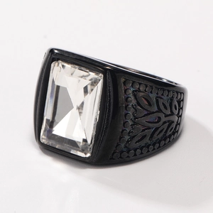 Macro shot of black stainless steel ring with a large rectangular clear gemstone and pattern