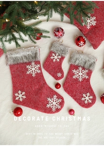 Detail of red Christmas stockings with white snowflake patch and soft faux fur collar trim