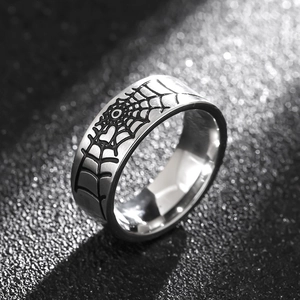 Spider web engraved 316L stainless steel ring with polished finish on a dark textured background