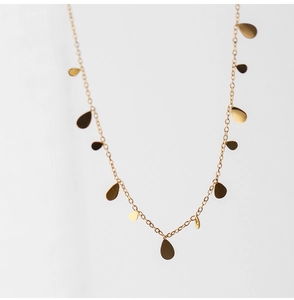 Detailed close-up of a gold titanium necklace featuring polished teardrop pendants