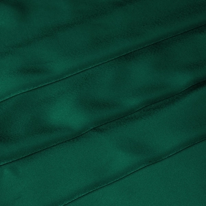 Macro shot of elegant dark green satin fabric showing smooth texture and light reflections