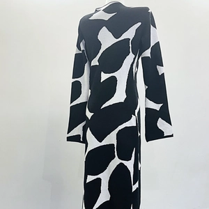 Detail of knitted long-sleeve dress showing abstract spotted pattern and thick texture