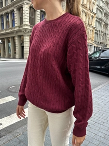 Detailed cable knit texture on a wine red long-sleeved crewneck sweater for women