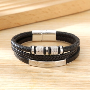 Close-up of multilayer braided black leather bracelet with silver magnetic buckle and beads