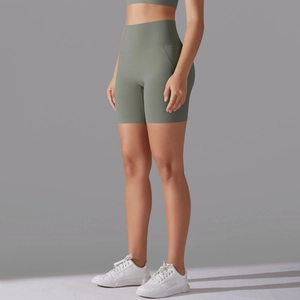 Detail view of high-waisted seamless sage green yoga shorts with ergonomic stitching