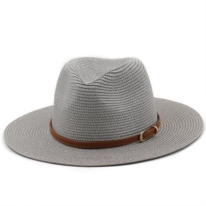Close-up of grey straw fedora hat featuring a brown leather band and golden metal buckle