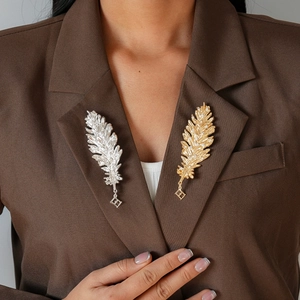 Vintage metal feather brooches with rhinestones and diamond pendants on suit lapels