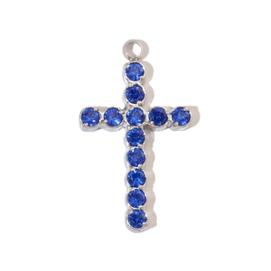 Macro shot of silver stainless steel cross pendant inlaid with round blue gemstones