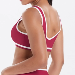 Détail d'une brassière de yoga rouge dos nu avec bordures contrastées blanches