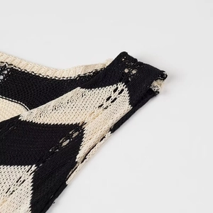 Detail der hohlen Stricktextur und des schwarz-weißen Streifenmusters am Schultergurt