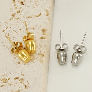 Detailansicht der gold- und silbernen Tulpen-Ohrstecker aus Edelstahl auf Naturstein