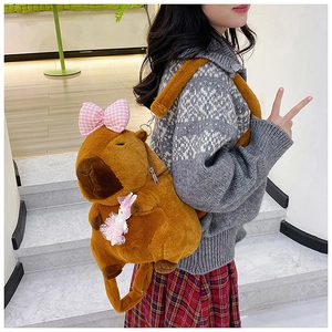 Detail of Capybara plush backpack featuring pink plaid bow and mini bunny accessory