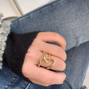 Close-up of chunky gold plated brass ring with unique irregular intertwined line design