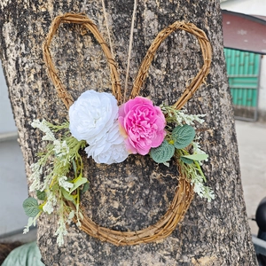 Detail of Easter bunny vine wreath with pink silk flowers and green eucalyptus leaves