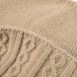 Women's thick knit beanie hat in beige with classic cable knit pattern and cozy wool texture