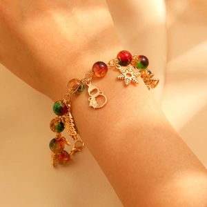 Close-up of Christmas charm bracelet with snowflake, snowman and colorful beads on wrist