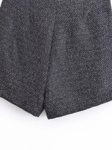 Close-up of black and white tweed fabric with metallic silk threads and sewing detail