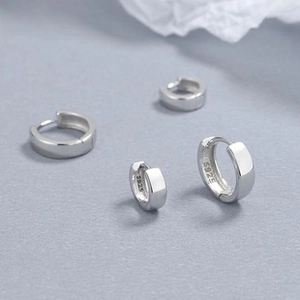 Macro shot showing S925 hallmark on polished minimalist sterling silver hoop earrings