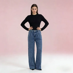 Detail of high-waist wide-leg denim jeans paired with a black knit sweater in a studio setting