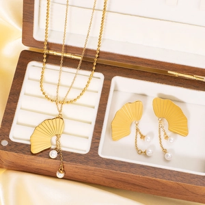 Elegant gold ginkgo leaf jewelry set with white pearls in a wooden display box