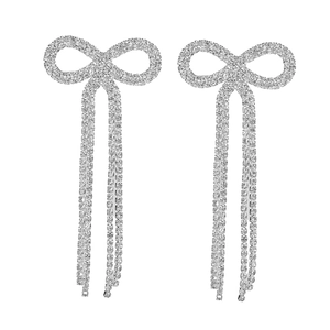Elegant silver bow earrings with sparkling rhinestones and long tassel chains on white background