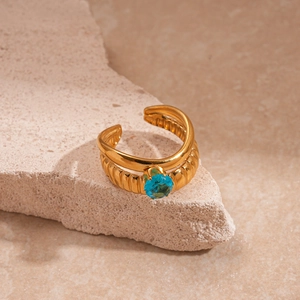 Gros plan détaillé de la bague double couche dorée avec zircon bleu sur pierre