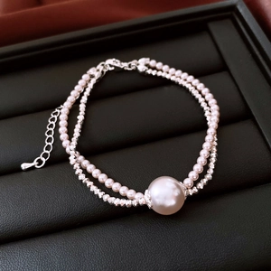 Detail view of double-layer pearl bracelet with silver accents on a jewelry tray