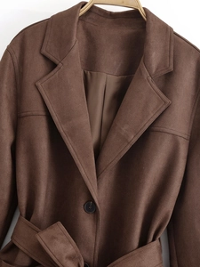 Detail of brown faux suede trench coat featuring classic notched lapels and black buttons