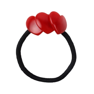 Detail view of elastic hair tie with three vibrant red heart-shaped acetate charms