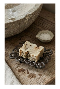 Close-up of vintage cast iron hollow soap dish with handmade soap on rustic wood