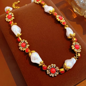 Detail showing vintage flower metal texture with red gemstone and baroque pearl