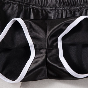 Dettaglio di pantaloncini sportivi neri con bordo bianco a contrasto e vita elastica