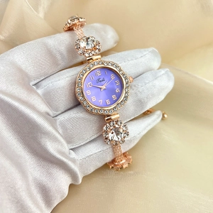 Detail of rose gold watch with purple dial, crystal bezel and floral rhinestone bracelet