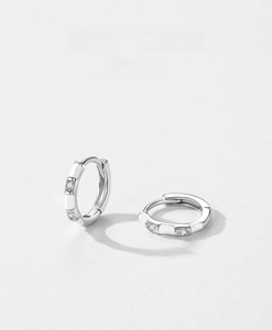 Detail of S925 sterling silver hoop earrings with white enamel and cubic zirconia stones