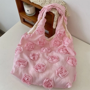 Detail of pink canvas tote bag featuring 3D floral rosettes and pleated shoulder straps