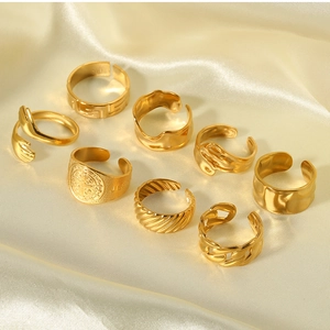 Detail of 8 gold minimalist rings including hug and twist motifs on soft satin