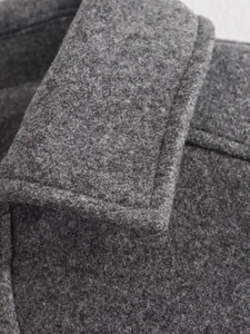 Close-up of charcoal grey wool blend fabric texture and collar stitching on casual jacket
