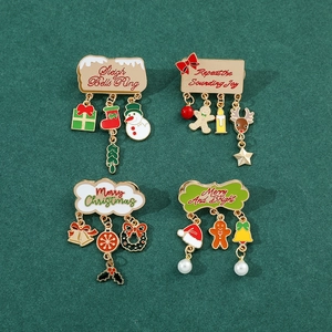 Detailed view of four festive Christmas enamel pins with dangling holiday charms