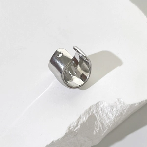 Polished silver U-shaped ear cuff on stone base with minimalist horseshoe design