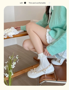 Close-up of ballet-style white lace socks with soft mesh and sweet bow detailing