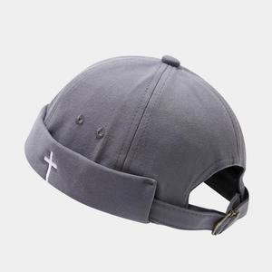 Detail of gray docker cap with white cross embroidery and adjustable metal buckle back