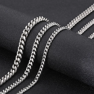 Detail showing various thicknesses of silver Cuban link chains on a black display