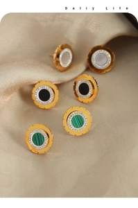 Detailed close-up of three pairs of gold-plated geometric earrings with zircon and colorful stones